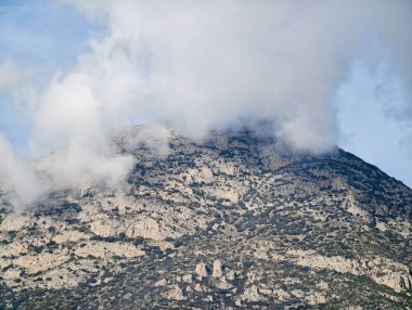 Alçak bulutlar ve sisle kaplı dağ yüzeyi, Alp gözlemi için korucu gözlem konsepti, desenli kaya