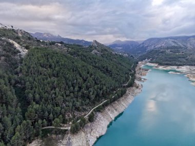 Hava manzaralı rezervuar turkuaz orman uçurumları kıyı bulutları yansıtıcı su dronu haritası