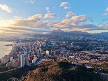 Sahil şehrinin üzerindeki dramatik bulutlar dinamik ışık ve gölgelerle ufuk çizgisi, körfez uzak buruna doğru kıvrılıyor.,