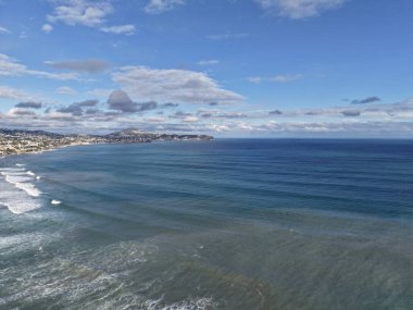 Kıyı sahili dalgaları geniş kıyı şeridini, burunları, dağınık şehirleri gösteriyor.