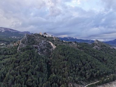 Gökyüzü manzaralı çam tepesi şapeli kayalık zirveye tünemiş, sık orman tepe örtüsü uzaklara sürükleniyor.