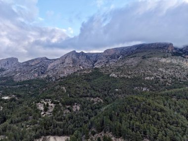 Uçsuz bucaksız orman denizine bakan kayalık kayalıklar, virajlı erişim rotası ve gözcü harabesi