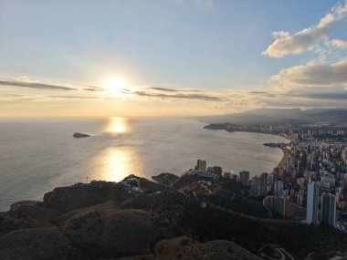 Sakin okyanus yüzeyinde yansıyan altın güneş, yumuşak bulutlar ve uzak ufuk çizgisi ile minimum bileşim,