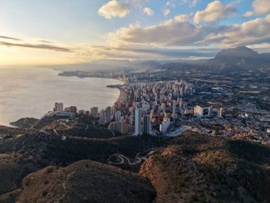 Hava şehri ufuk çizgisi kıyı koyunu kaplıyor, alacakaranlıkta yükseliş ve liman, planlama perspektifi