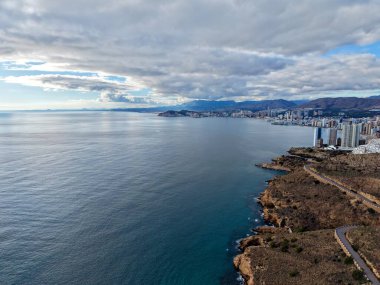 Hava uçurumu dolambaçlı yolu, küçük gözcü yapılarını ve panoramik denizi gösteriyor, macera için ideal.