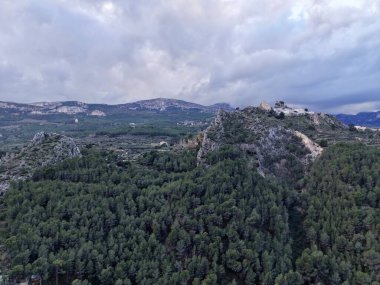 Yoğun çam ormanı tepe tepe gözcüleri ve dolambaçlı patikalar ile kaplı, yemyeşil gölgeler