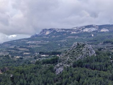 Vadi çam ormanı uzak kireçtaşı uçurumları, karamsar bulutlu ışık çarpıcı bir kontrastlık yaratıyor, geniş