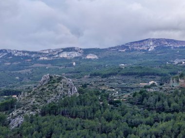 Bulutlu gökyüzünün altındaki hava orman sırtı, insansız hava aracı araştırma perspektifi kireçtaşı çıkıntısı, yoğun çam örtüsü,
