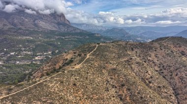 Dağ yolu bulut güvertesinin altında kıvrılarak ilerliyor. Korucu devriyesi perspektifi engebeli bir yolda, süpürüyor.