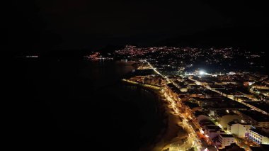 Gece yarısı kıyı şeridi sıcak ışıklar, sessiz körfezler ve binalar, uzun pozlama