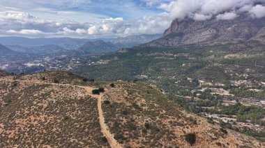 Tepe tepe manzarası ve vadi manzaralı şehir uzak dağlara doğru uzanan tozlu patika.