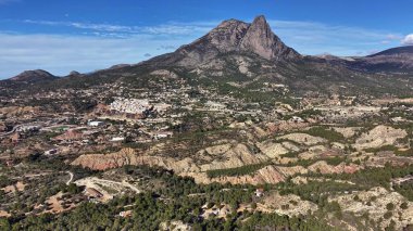 Şehrin yukarısındaki dramatik dağ sırtı dron operatörü perspektifi dik tepe ve güneşli yamaçlar gösteriyor.,
