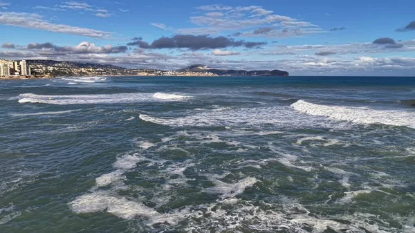 Şehir sahili dalgaları gezinti alanı ve binalar yakınında kırılıyor, şehir kıyı şeridi, hafif dalgalı, kıyı şeridi