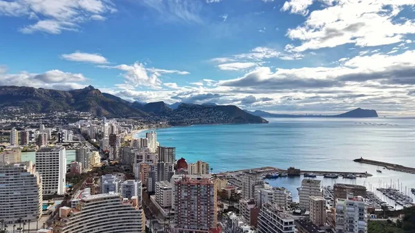 Güneşli kıyı silueti, gökdelen koyuna bakan gökdelenler, yüksek binalar ve yoğun marina, parıldayan su ve berrak