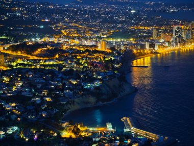 Cliffside kasabası geceleri aydınlanıyor, ev ve sokak lambaları kümeleri sükunet körfezine doğru çağlıyor, küçük