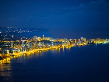 Mavi saat kıyı manzarası, uzak promontory ve sürekli kıyı aydınlatması, yumuşak donanma gökyüzü harmanlanması