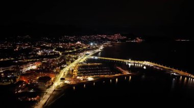 Hava gece köprüsü ışıkları liman kıvrımlı ufuk çizgisi kıvrımlı otoyolda parlıyor, trafik ipliklerini hareket ettiriyor, insansız hava aracı...