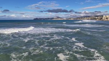 Çalkantılı yeşil sörf sahil kayalıklarını silip süpürüyor, güçlü dalgalar, sprey ve dalgalar, dramatik rüzgarlı su