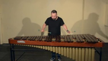 Perküsyon cubugu Marimba'daki Beyaz Oyun'da izole etti. Man Holding a Stick ve Bir Müzik Aleti Çalmak. İzole Müzik Aleti Marimba.
