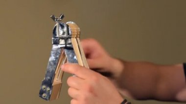 Perküsyon Enstrüman Ratchet oynayan bir adam . Parlak Duvarlar Arka Plan üzerinde.