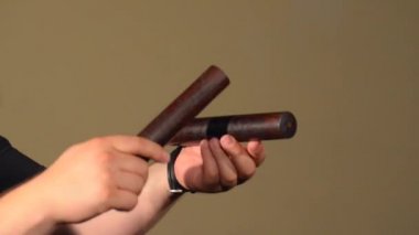 Perküsyon EnstrümanClaves oynayan bir adam. Parlak Duvarlar Arka Plan üzerinde.