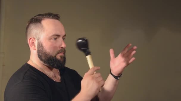 One Man With a Beard in Black T-Shirt, Playing on the Percussion Instrument Castanets. on the Bright Walls Background. — Stock Video