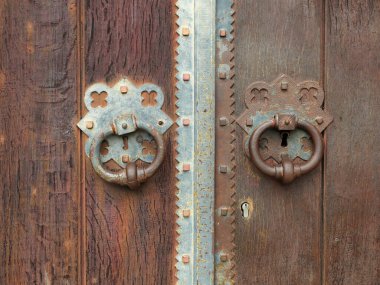 Eski ahşap kapısında grev levhası olan tarihi demir kapı tokmağı. Yakın plan. Kopyalama alanı.