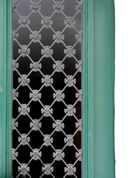 Elmas desenli metal ızgara ve çiçek süslemeleri, yeşil çerçeveli, koyu arkaplan. Kopyalama alanı.