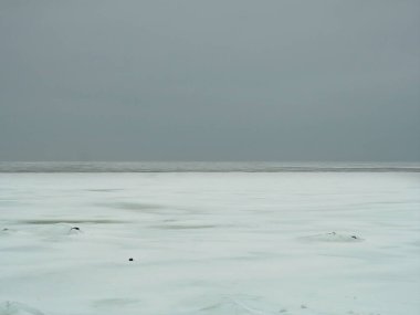 Donmuş Greifswald Bodden 'daki minimalist kış manzarası. Karla kaplı buz yüzeyi ve yumuşak gökyüzü sakin renk eğimine sahip kışın azalan bir bileşim oluşturur. Kopyalama alanı.