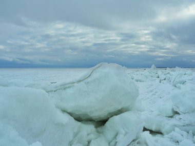 Buz tabakaları donmuş Baltık Denizi 'ndeki basınçla kıyıya itilmiş. Yeşil saydam katmanlar görünüyor. Donmuş Baltık Denizi Kıyısında Buz Kütleleri