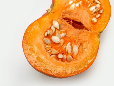 Yarım portakallı balkabağı, beyaz arka planda tohumlar.