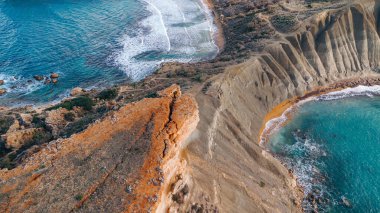 Malta 'nın engebeli kıyı şeridi, uçurumlar, deniz ve el değmemiş bir plaj manzarası..