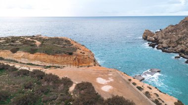 Malta 'daki kayalık kıyı şeridi, uçurumlar ve turkuaz deniz manzarası.