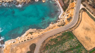 Malta 'nın kıyı şeridini turkuaz deniz, yol ve tarlalarla gösteren hava manzarası, adanın manzaralı güzelliğini yansıtıyor..
