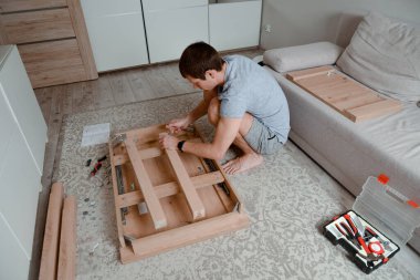 Evdeki mobilyaları monte eden adam. DIY projesi. İç mekan.