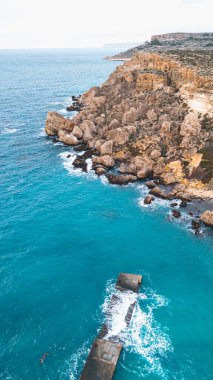 Malta 'daki kayalık kıyı şeridi ve turkuaz deniz manzarası.
