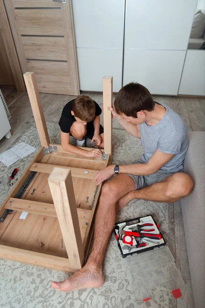 Baba ve oğlu mobilya montajı yapıyor. Bağlanma anı. DIY projesi evde.