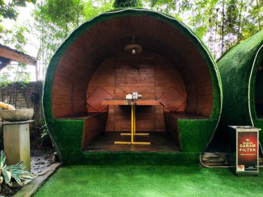 Bandung, Endonezya - 25 Aralık 2025: Yeşilin hakim olduğu bir restoranın açık hava yemek alanı