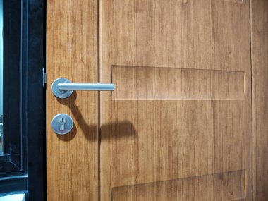 Kapı kolu ve anahtar deliğiyle ahşap desenli..