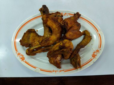 Beyaz tabakta birkaç parça kızarmış tavuk.