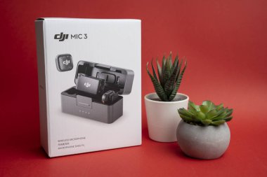 DJI Mic 3 kablosuz mikrofon sistemi, kompakt tasarımı ve yaratıcılar için hassas ses performansını ön plana çıkaran temiz ve modern bir stüdyo ortamında sergilenmektedir. Budapeşte Macaristan - 23. Kasım 2025