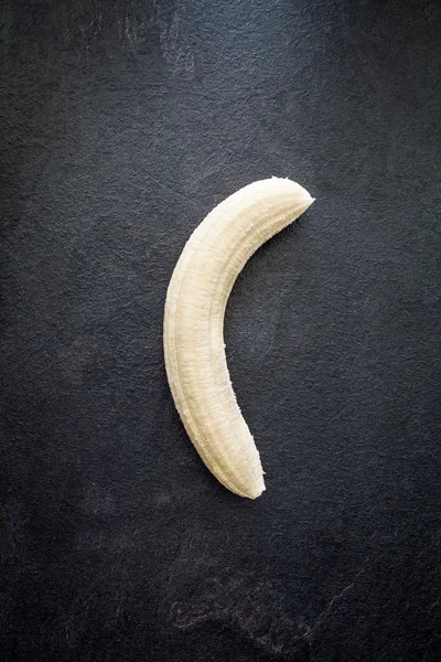 Geschälte Banane auf Schiefer — Stockfoto