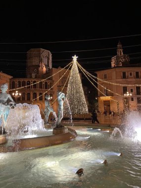 Valencia 'da Noel, Valencia sokaklarında yeni yıl ışıkları. Işıklandırılmış Noel ağacı ve Valencia Plaza de la Virgin 'deki Turia çeşmesi..
