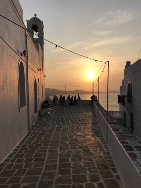 Yunanistan 'ın Milos Adası' ndaki Plaka şehrinde gün batımını izleyen insanlar.