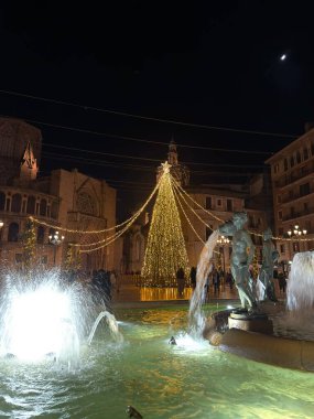 Valencia 'da Noel, Valencia sokaklarında yeni yıl ışıkları. Işıklandırılmış Noel ağacı ve Valencia Plaza de la Virgin 'deki Turia çeşmesi..