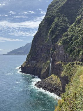 Yeşil uçurumdan mavi Atlantik Okyanusuna akan şelale, Miradouro Veu da Noiva bakış açısı, Madeira Adası doğa, Portekiz