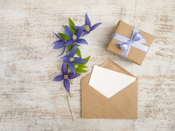 Hediye kutusu, mavi çiçekler ve tebrik kartı