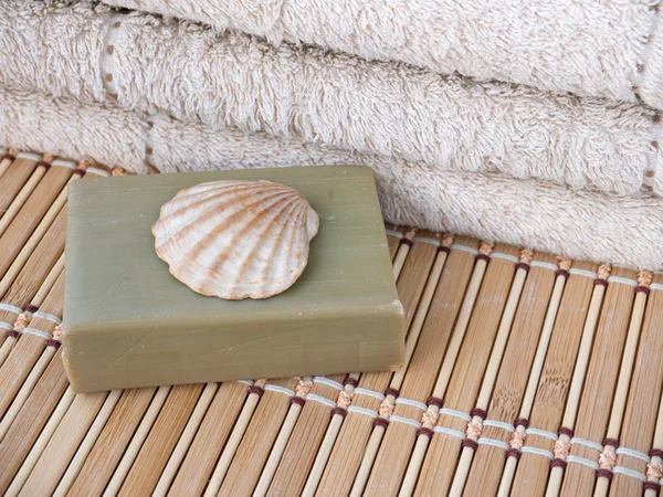Оливковое мыло, раковина гребешка и махровое полотенце — стоковое фото
