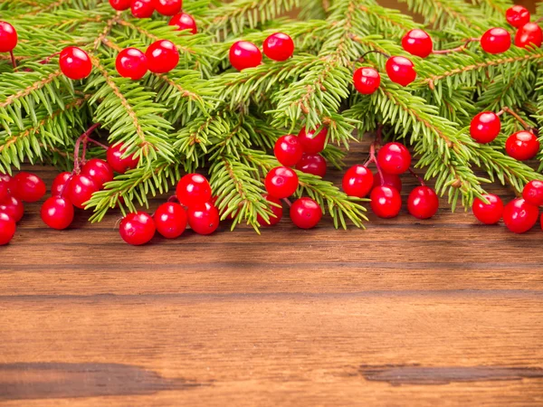 Vánoční strom a červené bobule na tmavém pozadí — Stock fotografie