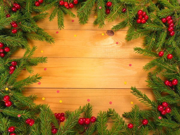 Vánoční strom a červené bobule rám na dřevěné pozadí — Stock fotografie
